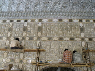 Amber fort, Jaipur, Rajasthan, India, August 17, 2011: Three men restore one of the walls of the...