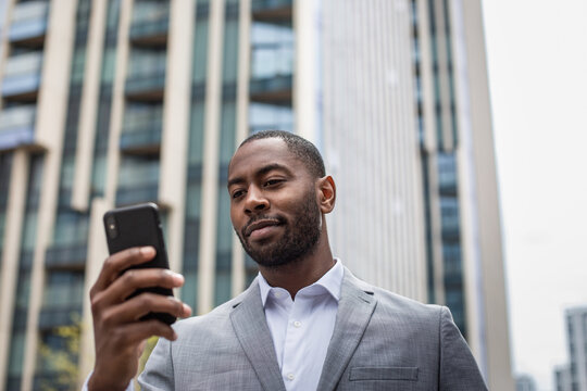 Businessman walking in city using smartphone