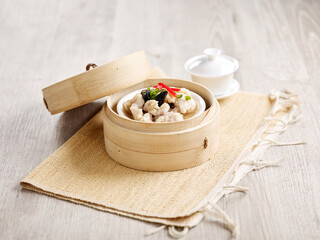 Obraz na płótnie Canvas Steamed Spare Ribs with Diced Yam served in a wooden bowl with chopsticks isolated on mat side view on grey marble background