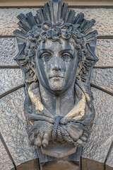 Old relief bar, a keystone in a building arch, of a woman face in the historical downtown of Dresden, Germany, details, closeup.
