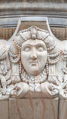 Old relief bar, a keystone in a building arch, of a woman face in the historical downtown of Dresden, Germany, details, closeup.