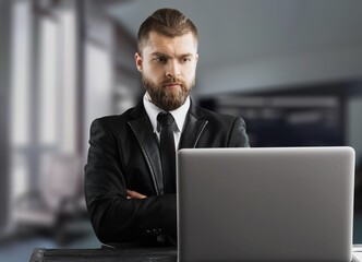 Busy Young Businessman Using Computer in Modern Office. Manager Thinks About Successful Financial Ideas.