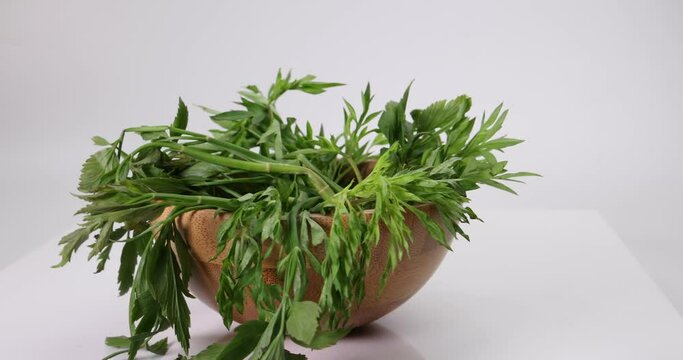 Malaysian Malay herbal leafy appetizer dish daun ulam raja selom lovage in small wooden bowl on white background