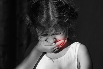 Toothache in a child, a girl of 6 years old covered her mouth in pain