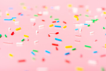 Fototapeta na wymiar colorful sprinkles over pink background, decoration