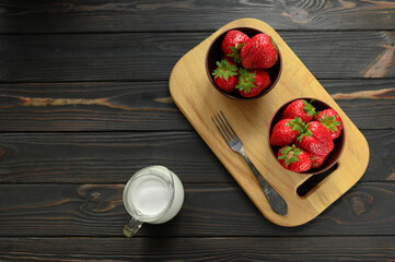 A bowl of red juicy strawberries on rustic wooden table. Healthy and diet snack food concept.