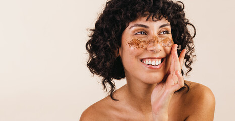 Woman treating her face with coffee scrub