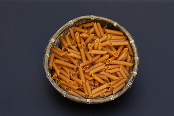 Wholemeal macaroni photographed on black background