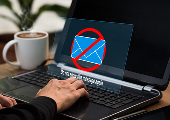 A businesswoman works on her laptop computer with a caution box shown on the screen. Spam e-mail...
