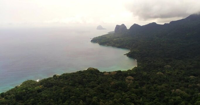 Flying foward over the biosphere forest with the Jockey hat as background at Prince Island,Sao Tome,Africa