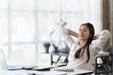 Portrait of beautiful asian woman relaxing in office, Happy relaxed woman having break and resting in office.