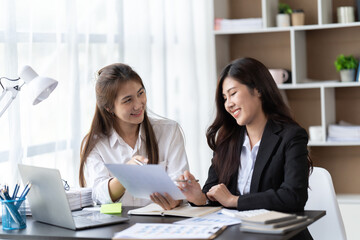 Coworkers looking at a computer and discussing over new business plan. Business team working together on computer in office,