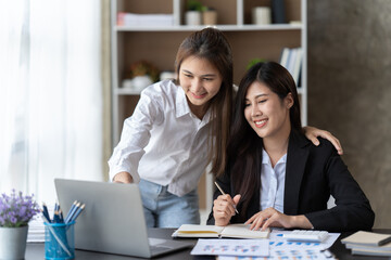 Coworkers looking at a computer and discussing over new business plan. Business team working together on computer in office,