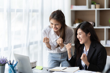 Coworkers looking at a computer and discussing over new business plan. Business team working together on computer in office,