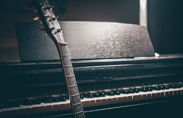 Guitar and electronic piano in a dark room close-up. © puhimec