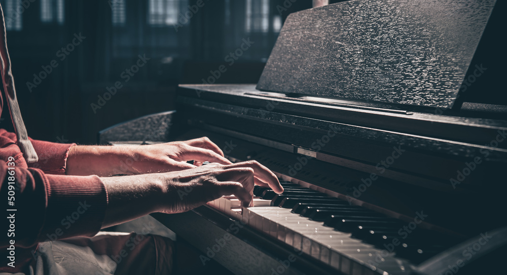 Wall mural A man plays an electronic piano in a dark room.