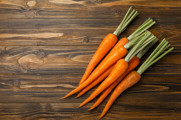 Fresh and sweet carrots on a brown wooden table.Healthy vegan food.Fresh organic carrots.Vegetables. Healthy food.Space for copy.