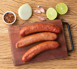 Calabrese pork sausage over wooden board with seasonings