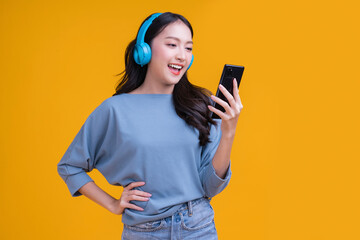 happiness carefree asian young female woman teen wearing headphone smartphone listen music joyful fun moving moment ,teen wear casaul cloth singing move while laugh smile trendy lifestyle studio shot