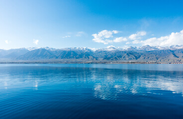 Sverny shore of Lake Issyk-Kul, Kyrgyzstan. View from the ship to the shore. Blue water of a mountain lake.