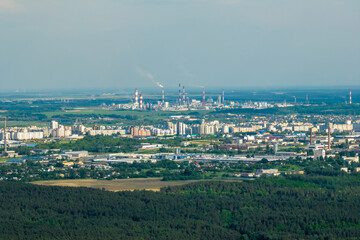 ariel panoramic view of city and skyscrapers with a huge factory with smoking chimneys in the background