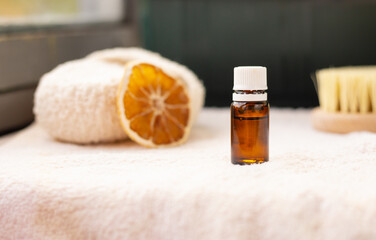 ESSENTIAL OIL in dark bottle , white towel, body brush, copy space, spa procedures products, eco cosmetic