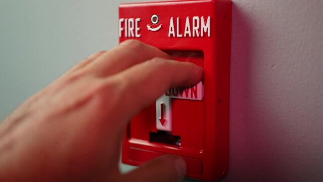 An extreme slow motion closeup view pulling down a fire alarm in a commercial building.  	
