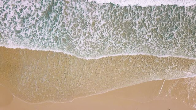 B roll - Summer topical sand beach and sea wave. Aerial view of drone. Top view of surf on sand. Beautiful of sunset white sand beach. Perfect for holiday summer background. Slow motion, Cinematic.
