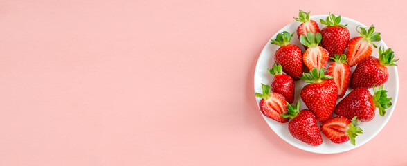Fresh strawberries flat lay close-up on a pink background. extra wide banner . Fresh berries, summer harvest, fruits, healthy food, diet concept. copy space for text