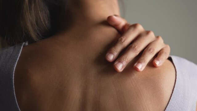 Asian woman has shoulder pain. Female holding painful shoulder with another hands. People with body-muscles problem, Healthcare And Medicine.
