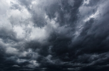 The dark sky with heavy clouds converging and a violent storm before the rain.Bad or moody weather sky.