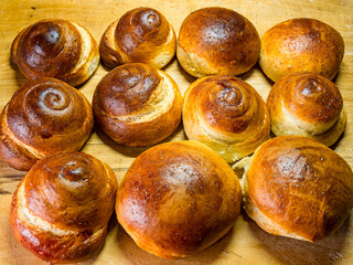 Freshly baked sweet buns and rolls buns on a wooden background - selective focus