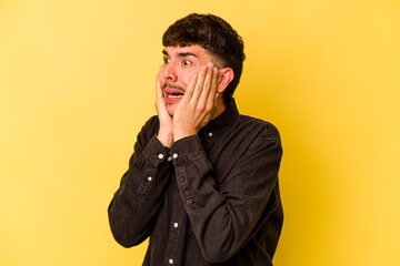 Young caucasian man isolated on yellow background scared and afraid.