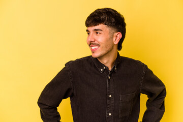 Young caucasian man isolated on yellow background confident keeping hands on hips.