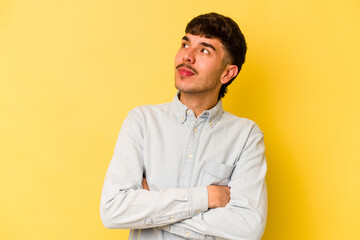 Young caucasian man isolated on yellow background dreaming of achieving goals and purposes