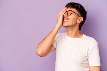 Young caucasian man isolated on purple background laughing happy, carefree, natural emotion.