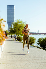 Young woman taking running exercise by the river promenade