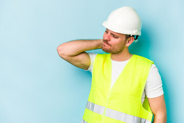 Young laborer caucasian man isolated on blue background touching back of head, thinking and making a choice.