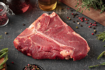 Side view on raw t bone steak meat on grey decorated background