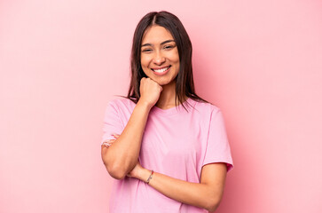 Obraz premium Young hispanic woman isolated on pink background smiling happy and confident, touching chin with hand.