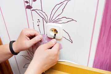 The plug and socket are burned, the man is holding a burnt socket.Short circuit, fire, danger. The...