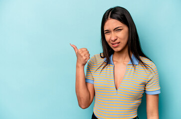 Young hispanic woman isolated on blue background shocked pointing with index fingers to a copy space. - obrazy, fototapety, plakaty