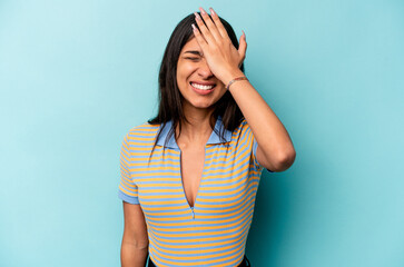 Fototapeta Young hispanic woman isolated on blue background forgetting something, slapping forehead with palm and closing eyes. obraz