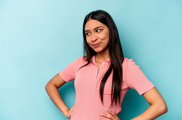 Young hispanic woman isolated on blue background dreaming of achieving goals and purposes