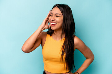 Young hispanic woman isolated on blue background joyful laughing a lot. Happiness concept.