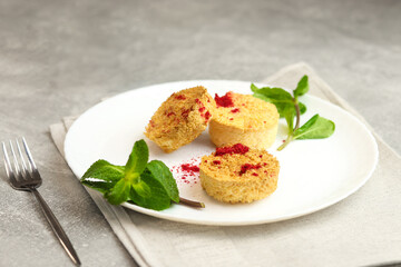 Delicious crispy dietary coconut cookies on a white plate on gray background. Close-up.