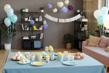 Image of holiday table served with desserts, cupcakes, donuts and other sweets preparing for...