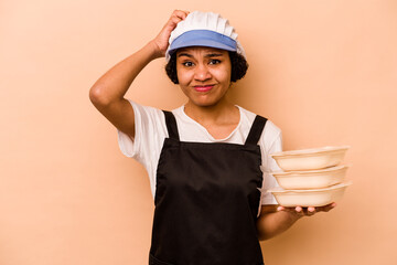 Young cook volunteer African American woman isolated on beige background being shocked, she has remembered important meeting.