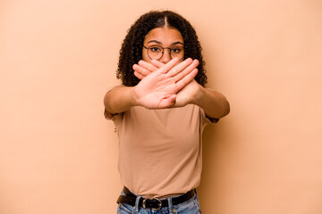 Young African American woman isolated on beige background doing a denial gesture