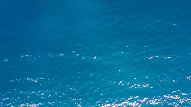 Sun rays in blue sea water. Glare of the sun on blue sea water.